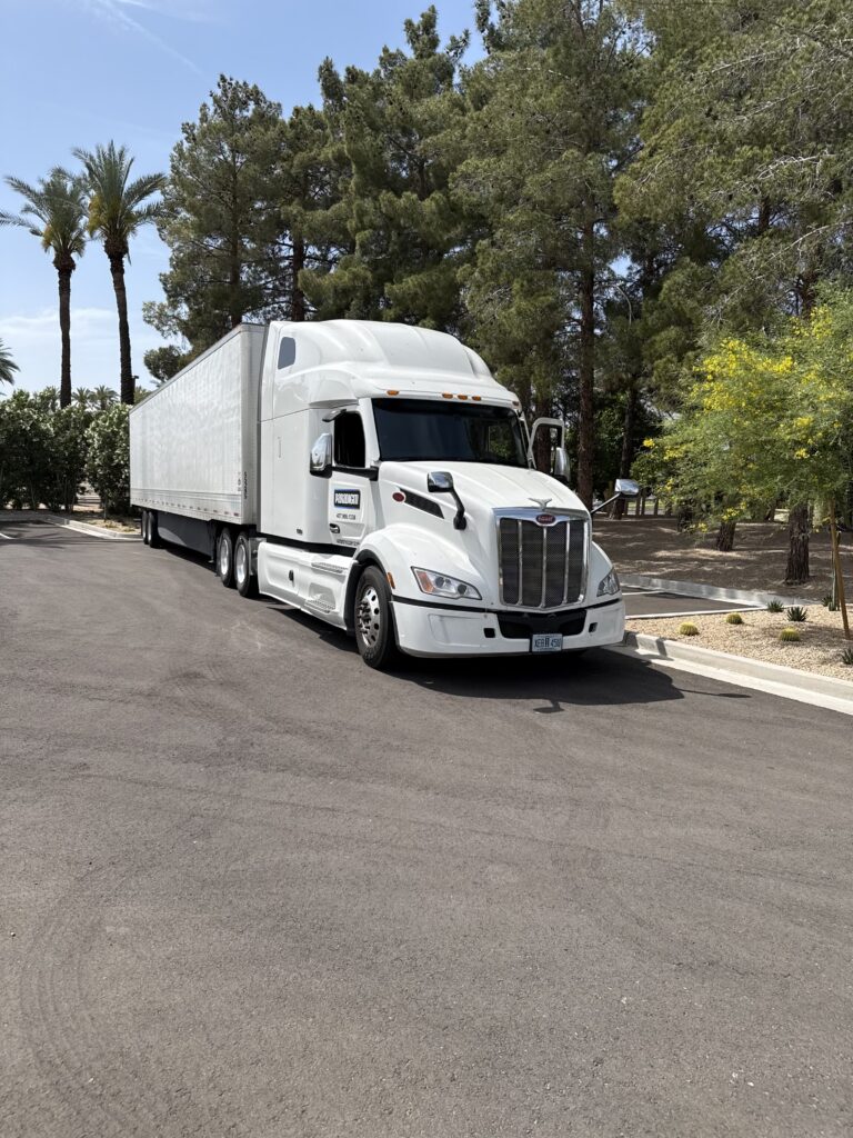 Paradigm Productions Group 53-foot semi truck and trailer arriving at a palm-lined venue, loaded with event production gear